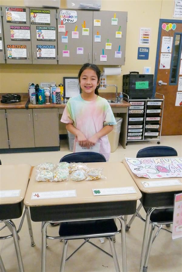 girl smiling with bags on her desk